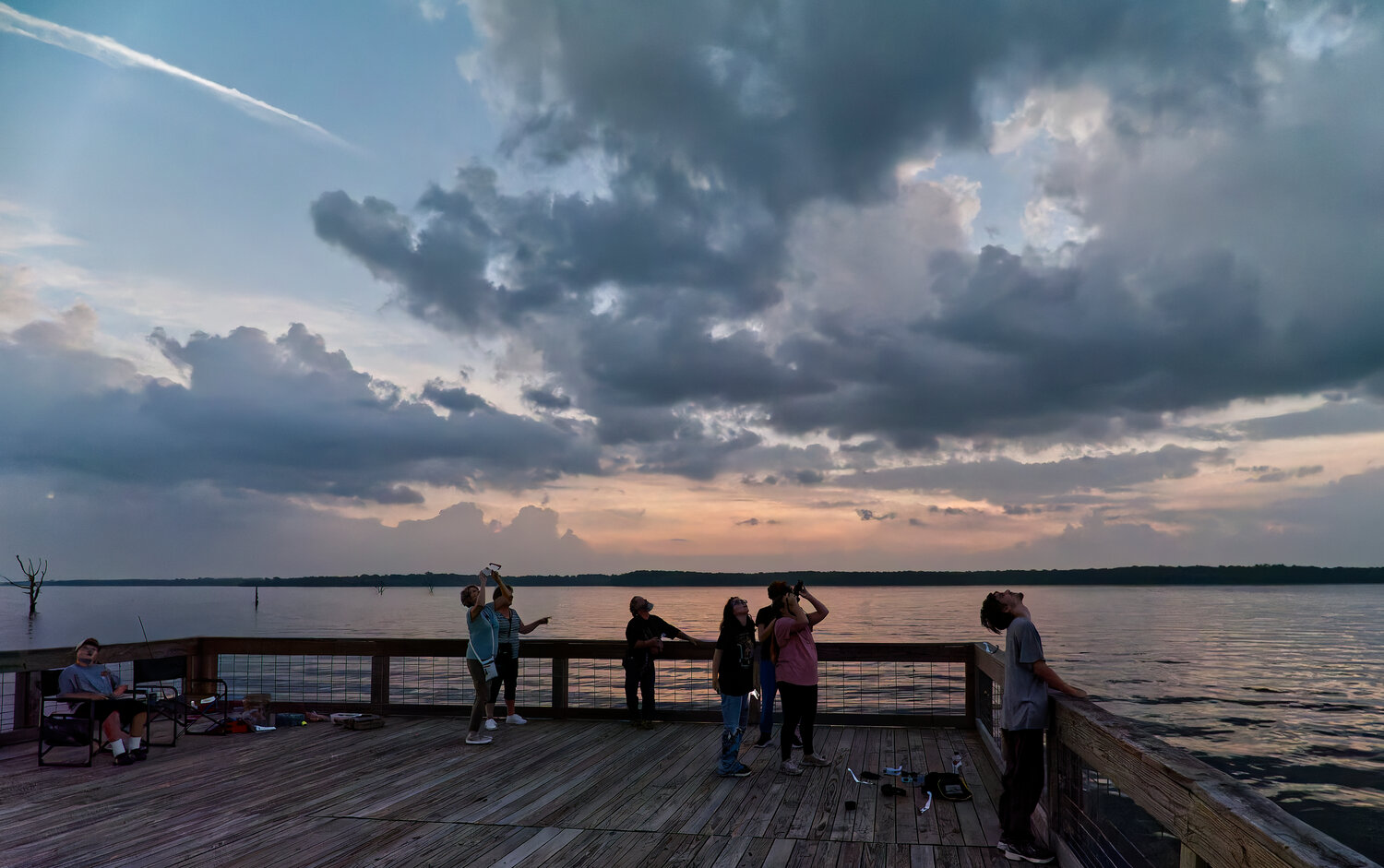 Onlookers at Swearingen Park on Lake Fork observe the total solar eclipse, as the horizon appears as though the sun were setting in all directions – here, north – despite being midday. [view more eclipse photos]